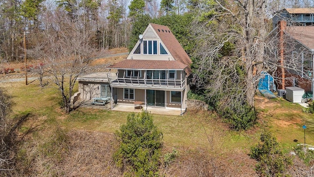 rear view of property featuring a patio area and a lawn