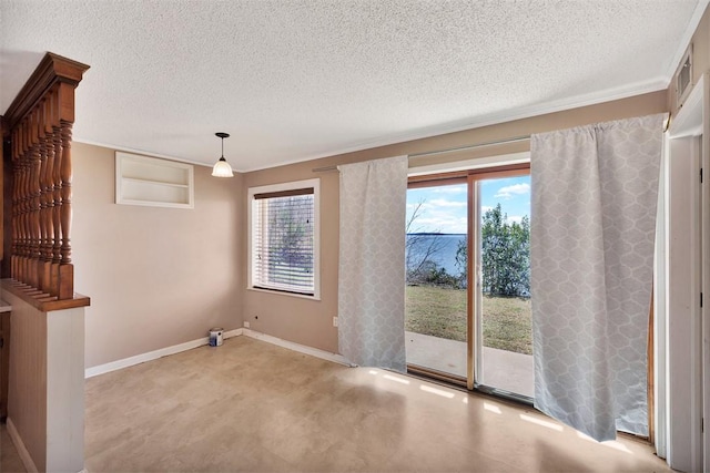 unfurnished room with a healthy amount of sunlight, a textured ceiling, and baseboards