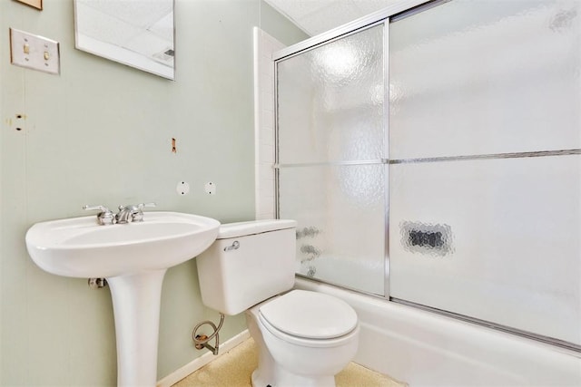 full bath with baseboards, combined bath / shower with glass door, and toilet