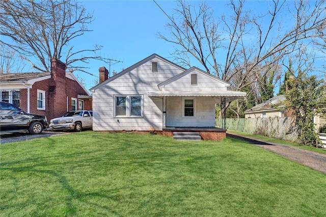 bungalow-style home with covered porch and a front lawn