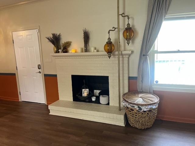 interior space with a fireplace, ornamental molding, and wood finished floors