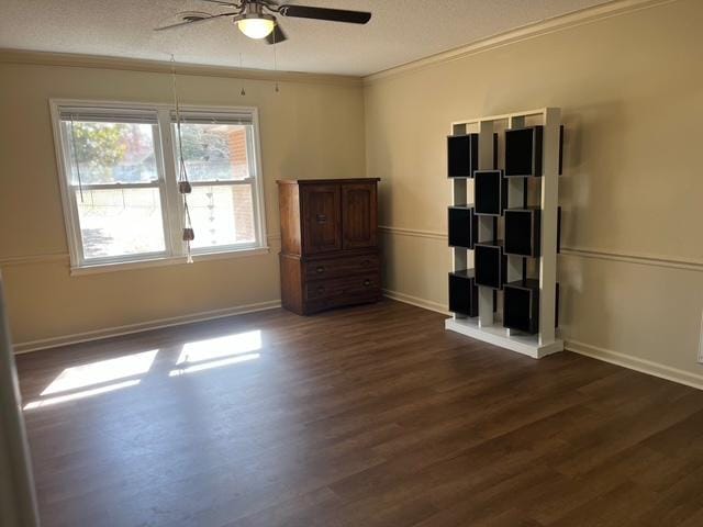 unfurnished bedroom with a textured ceiling, dark wood-type flooring, a ceiling fan, baseboards, and crown molding