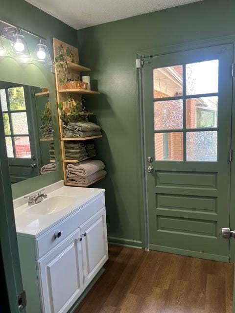 doorway to outside with dark wood finished floors and a sink