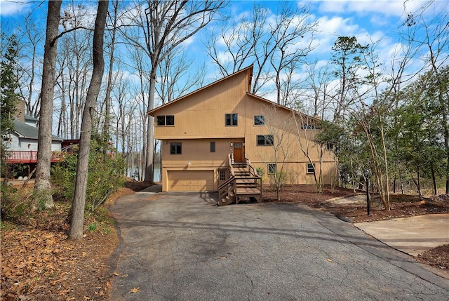 view of side of property with aphalt driveway and an attached garage