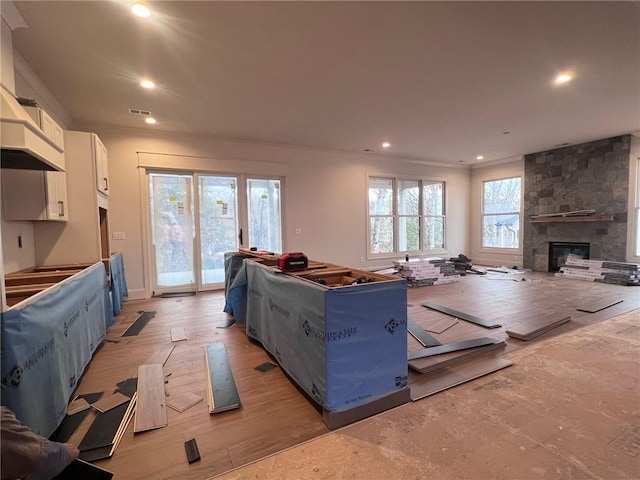 living room with visible vents, a fireplace, light wood-style flooring, and recessed lighting