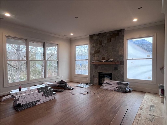 unfurnished living room featuring a fireplace, recessed lighting, hardwood / wood-style floors, ornamental molding, and baseboards