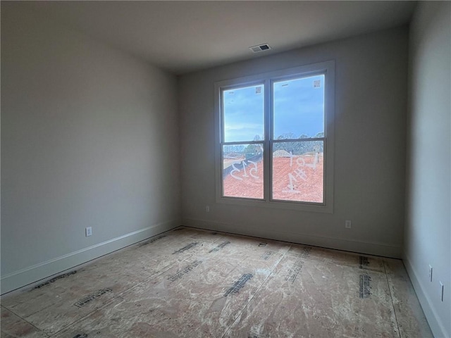 unfurnished room with baseboards and visible vents