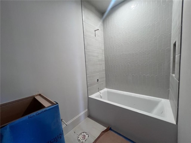 bathroom featuring baseboards, bathtub / shower combination, and tile patterned floors