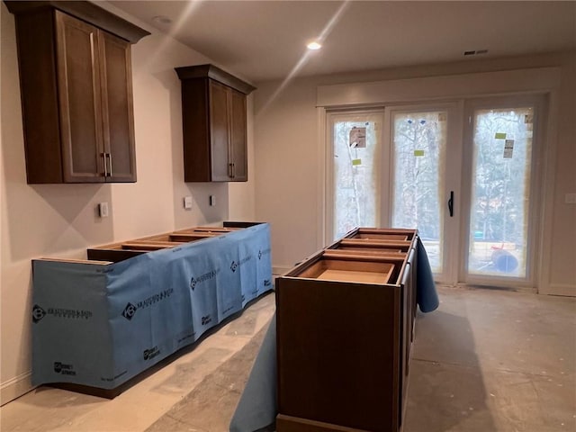 kitchen with recessed lighting, visible vents, a kitchen island, and dark brown cabinetry