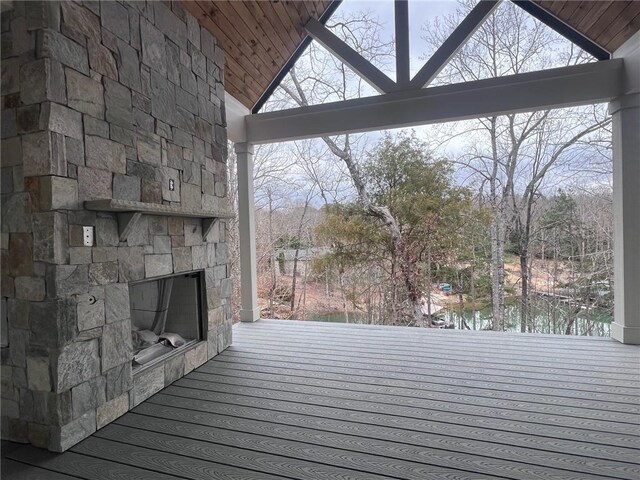 wooden terrace with an outdoor stone fireplace