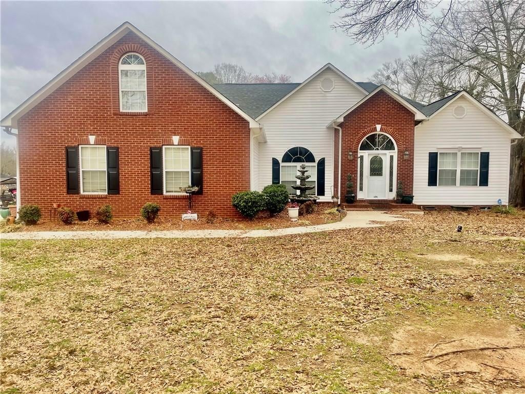 view of front of property with brick siding and a front lawn