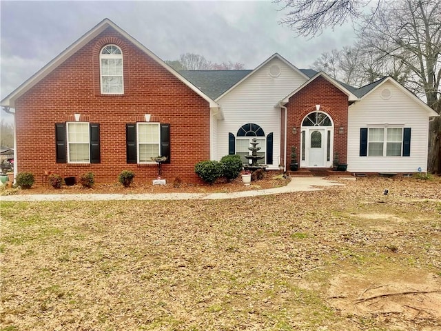 view of front of property with brick siding and a front lawn