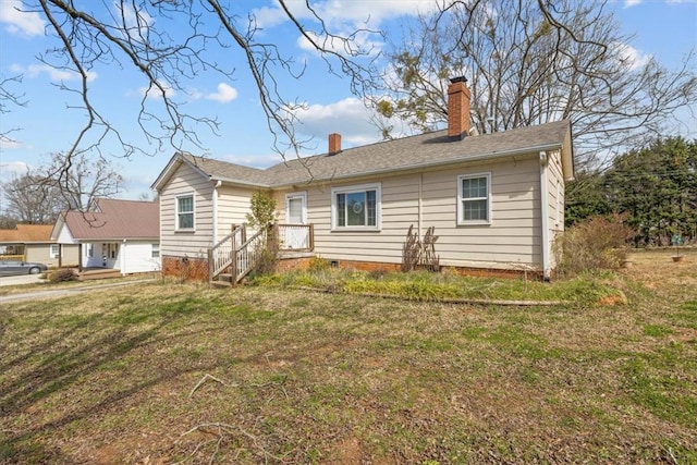 view of front of home featuring crawl space, a chimney, and a front yard