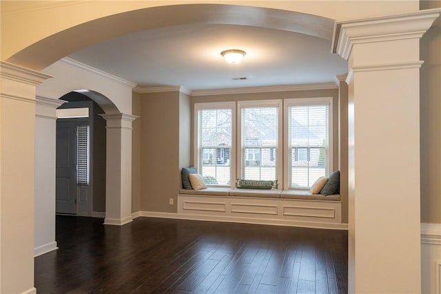 unfurnished room featuring visible vents, ornate columns, arched walkways, ornamental molding, and dark wood-type flooring