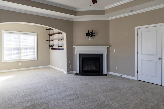 unfurnished living room with carpet floors, baseboards, crown molding, and a fireplace with flush hearth