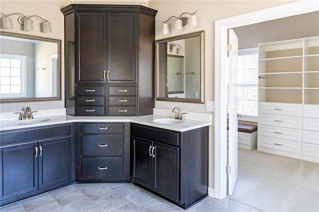 full bath featuring a healthy amount of sunlight, two vanities, and a sink