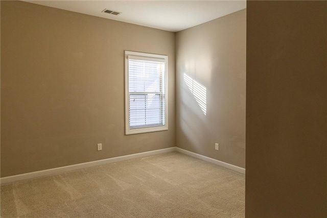 unfurnished room with light colored carpet, visible vents, and baseboards