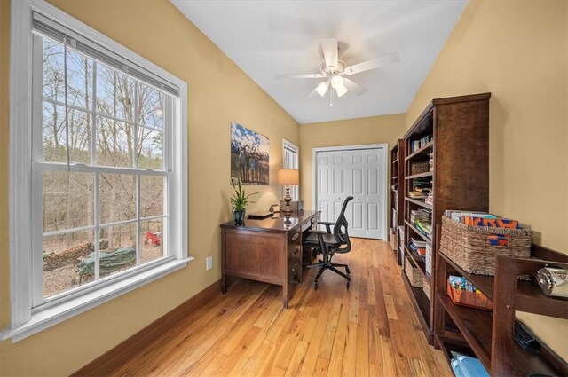 office with light wood finished floors, a ceiling fan, and baseboards