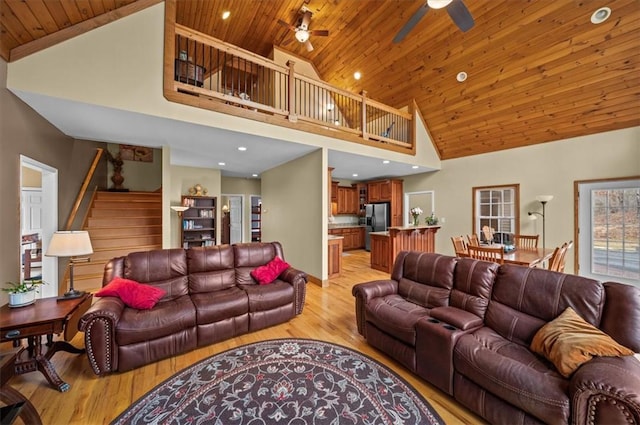 living room featuring stairway, ceiling fan, high vaulted ceiling, light wood-type flooring, and wooden ceiling