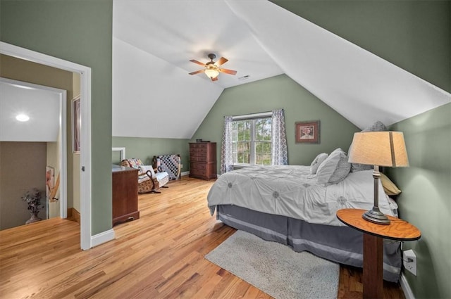 bedroom with lofted ceiling, wood finished floors, a ceiling fan, and baseboards