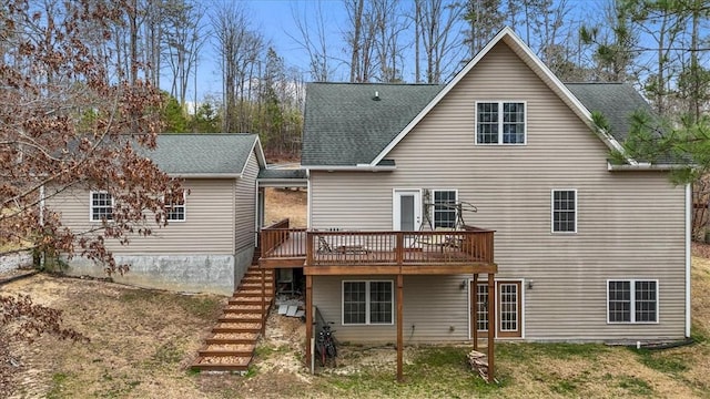 back of property with stairs, a deck, and roof with shingles