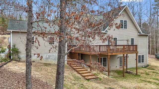 rear view of house with a wooden deck, stairway, a shingled roof, and a yard