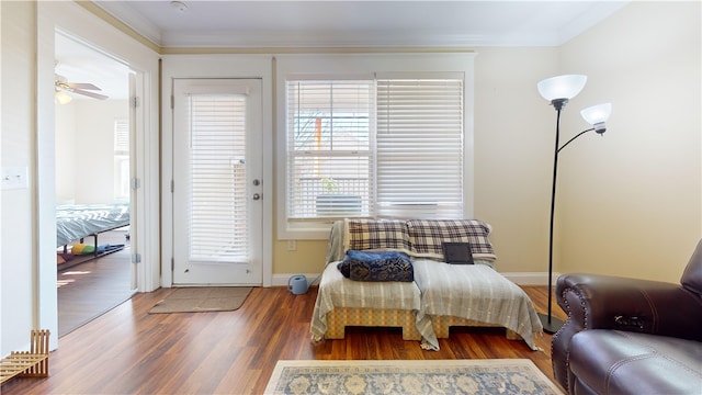 bedroom featuring baseboards, ornamental molding, and wood finished floors