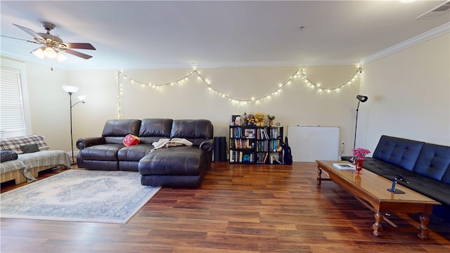 living room with a ceiling fan, visible vents, crown molding, and wood finished floors