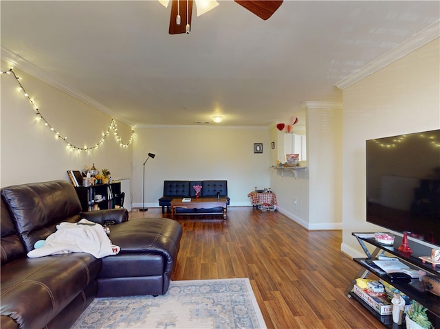 living room with ornamental molding, wood finished floors, and baseboards