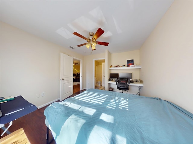 bedroom featuring baseboards, visible vents, built in study area, ceiling fan, and wood finished floors