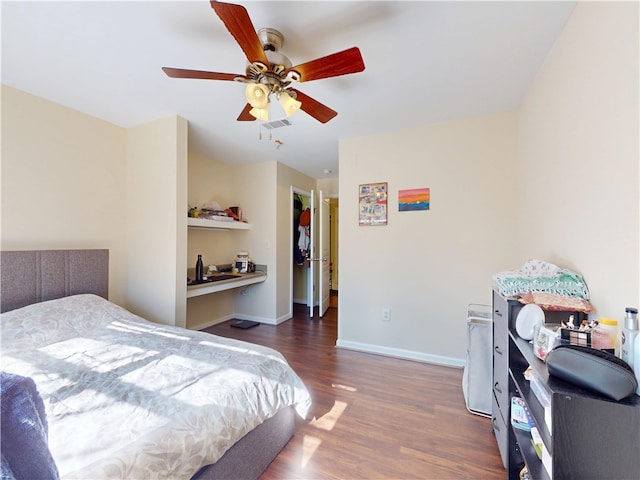 bedroom featuring ceiling fan, wood finished floors, visible vents, and baseboards