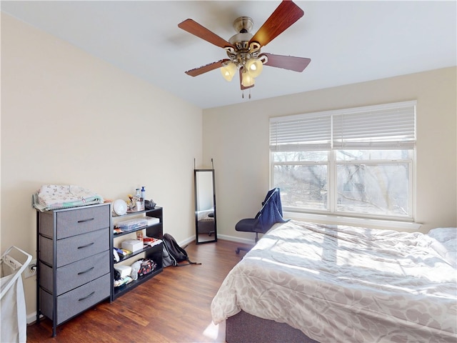 bedroom featuring ceiling fan, baseboards, and wood finished floors