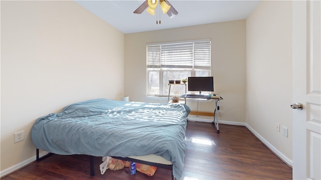 bedroom featuring wood finished floors, a ceiling fan, and baseboards