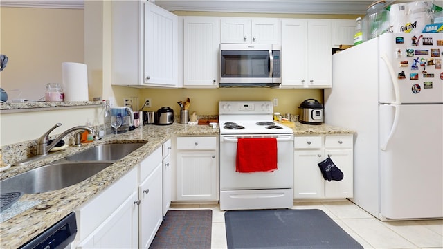 kitchen featuring white appliances, light tile patterned flooring, a sink, and white cabinetry