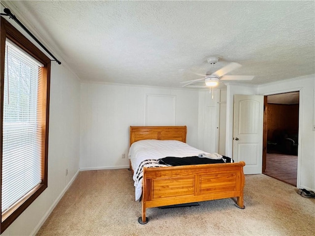 bedroom featuring light colored carpet, ceiling fan, a textured ceiling, and baseboards