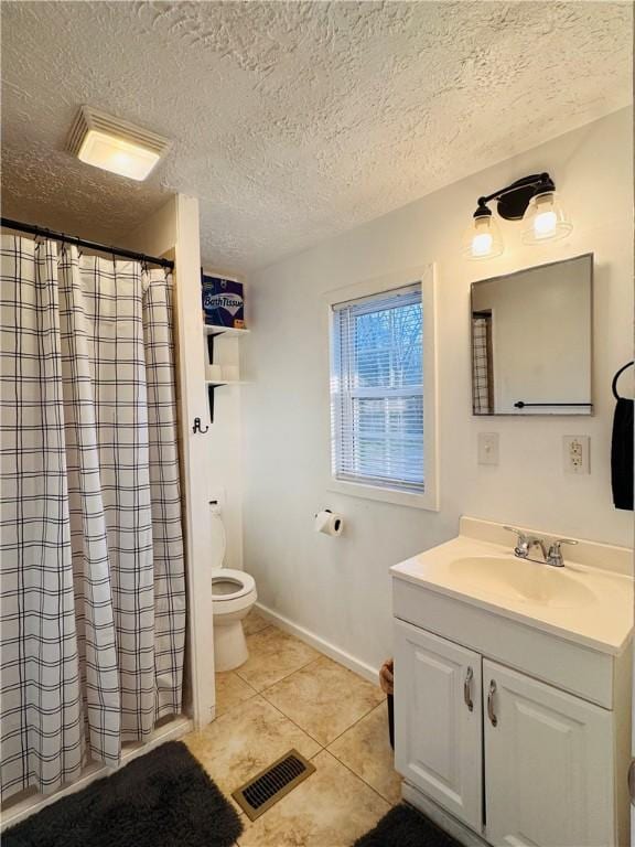 bathroom featuring tile patterned flooring, toilet, vanity, visible vents, and baseboards