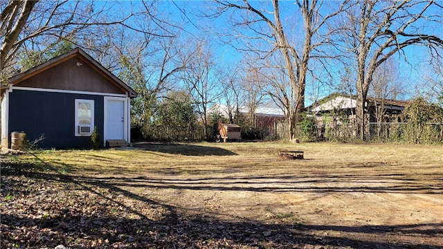 view of yard featuring an outbuilding, a shed, cooling unit, and fence