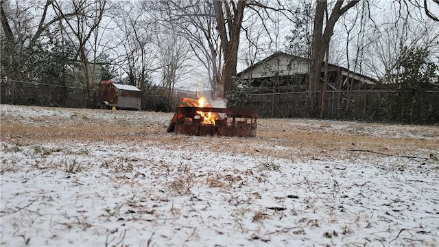 view of yard with an outdoor fire pit, fence, and an outbuilding