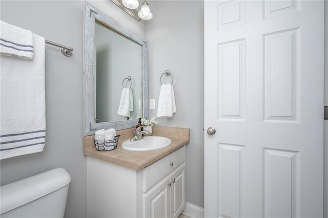 half bathroom with toilet and vanity