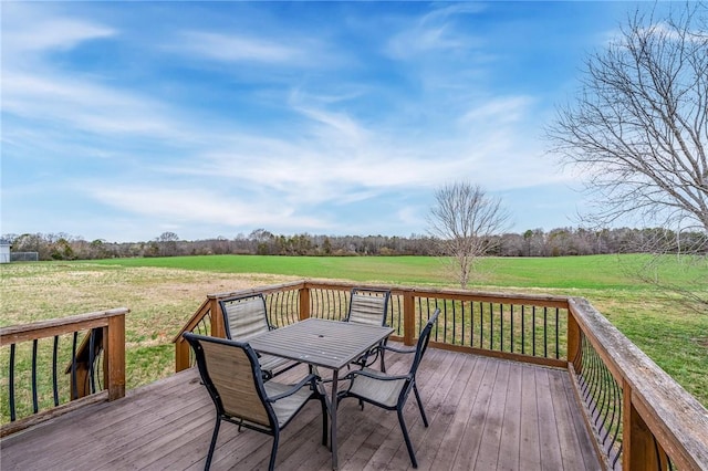 wooden deck featuring a yard, a rural view, and outdoor dining space