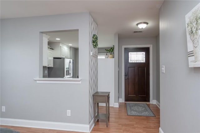 entryway with light wood-type flooring, visible vents, baseboards, and recessed lighting