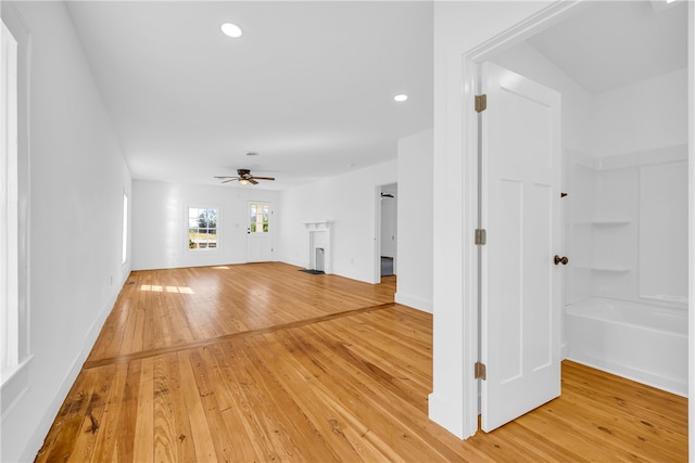 unfurnished living room featuring a ceiling fan, light wood-style flooring, recessed lighting, and baseboards