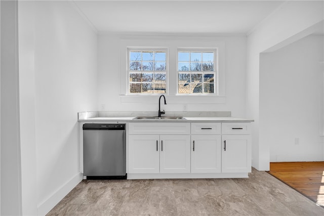 kitchen featuring a sink, light countertops, ornamental molding, white cabinets, and stainless steel dishwasher