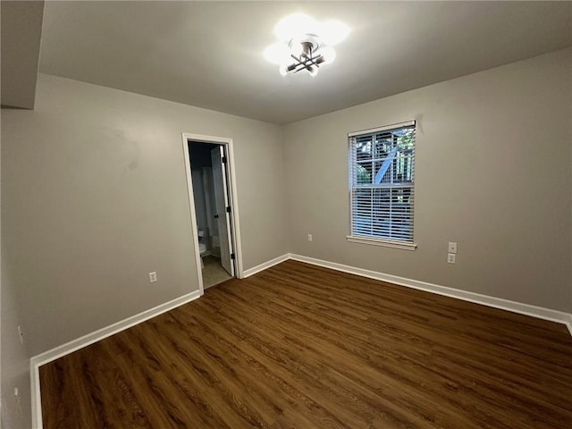 unfurnished room featuring dark wood finished floors and baseboards