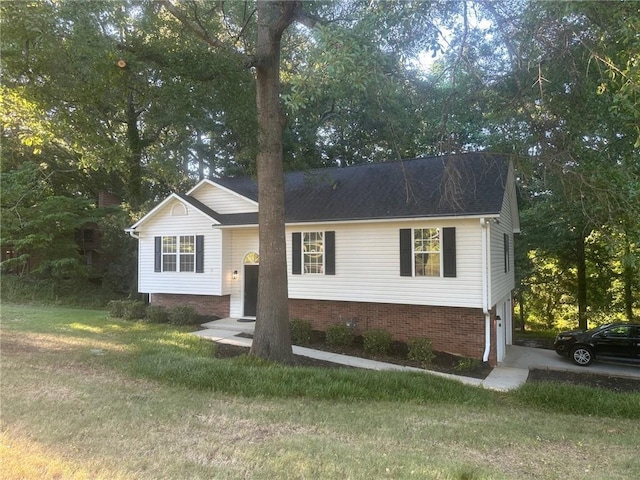 view of front of house with a garage, driveway, brick siding, and a front yard