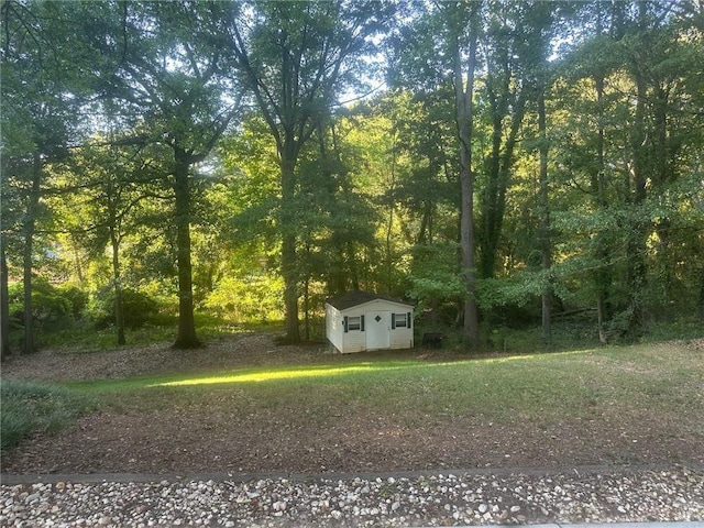 view of yard with a view of trees and an outdoor structure