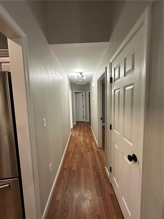 hall with baseboards and wood finished floors