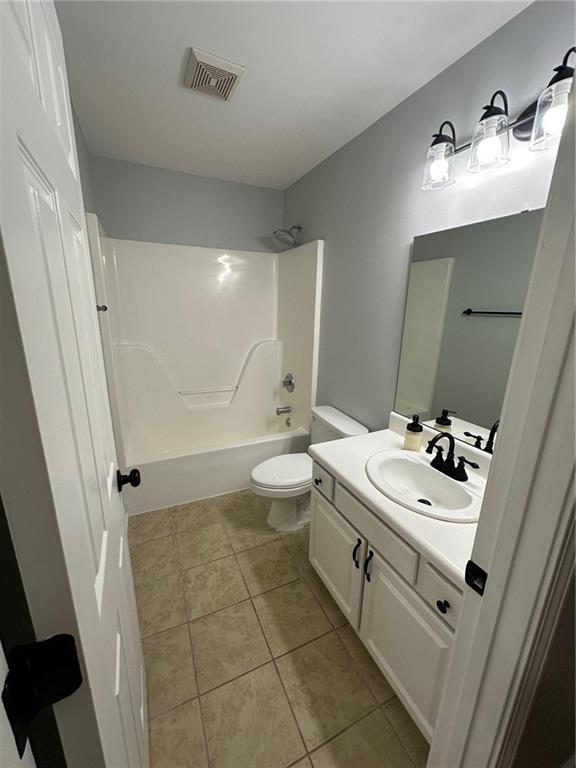 full bathroom with vanity, visible vents, tile patterned flooring, shower / bathing tub combination, and toilet