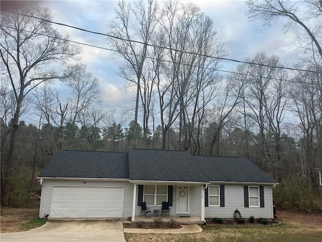 single story home featuring a porch, driveway, roof with shingles, and an attached garage