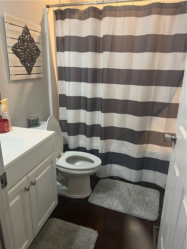 full bathroom with vanity, a shower with shower curtain, toilet, and wood finished floors